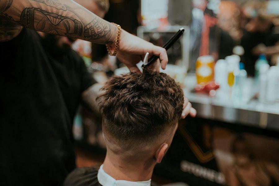 Barber cutting hair with scissors